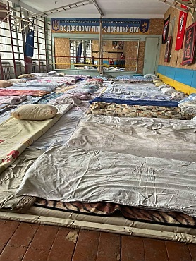 Hier sehen Sie ein Bild der umfunktionierten Turnhalle mit Betten.