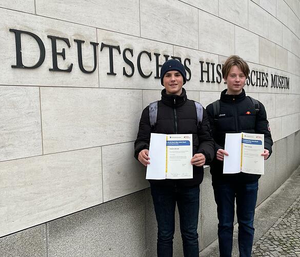 Torge Harms und Simon Meyer mit ihren Urkunden vor dem DHM.